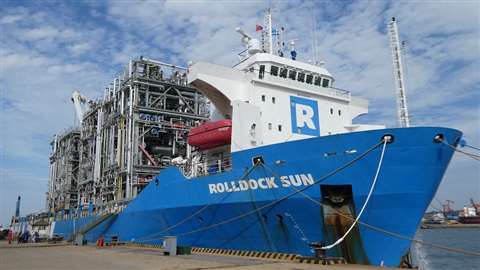 RollDock S-class heavy lift vessel RollDock Sun with a blue hull and white superstructure and carrying pipe rack modules