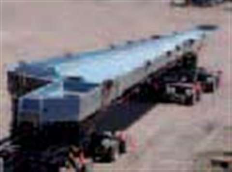 Late-model powerful tractors, specifically designed and outfitted for super heavy loads, towed a con