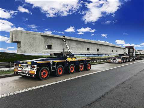 Faymonville FlexMax self steering dolly trailer with pedular axles, red and carrying a big concrete beam