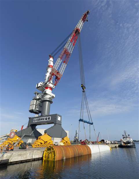 The Liebherr TCC 78000 heavy lift rail mounted gantry crane lowers a monopile into the dock