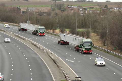 Police vehicles escorting the bridge cargo as it travels along the UK motorway