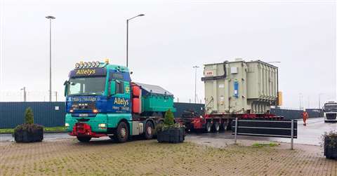 Allelys blue and turquoise STGO 3 four axle MAN ballasted tractor and red 14 axle line modular trailer carrying large beige ABB power station module